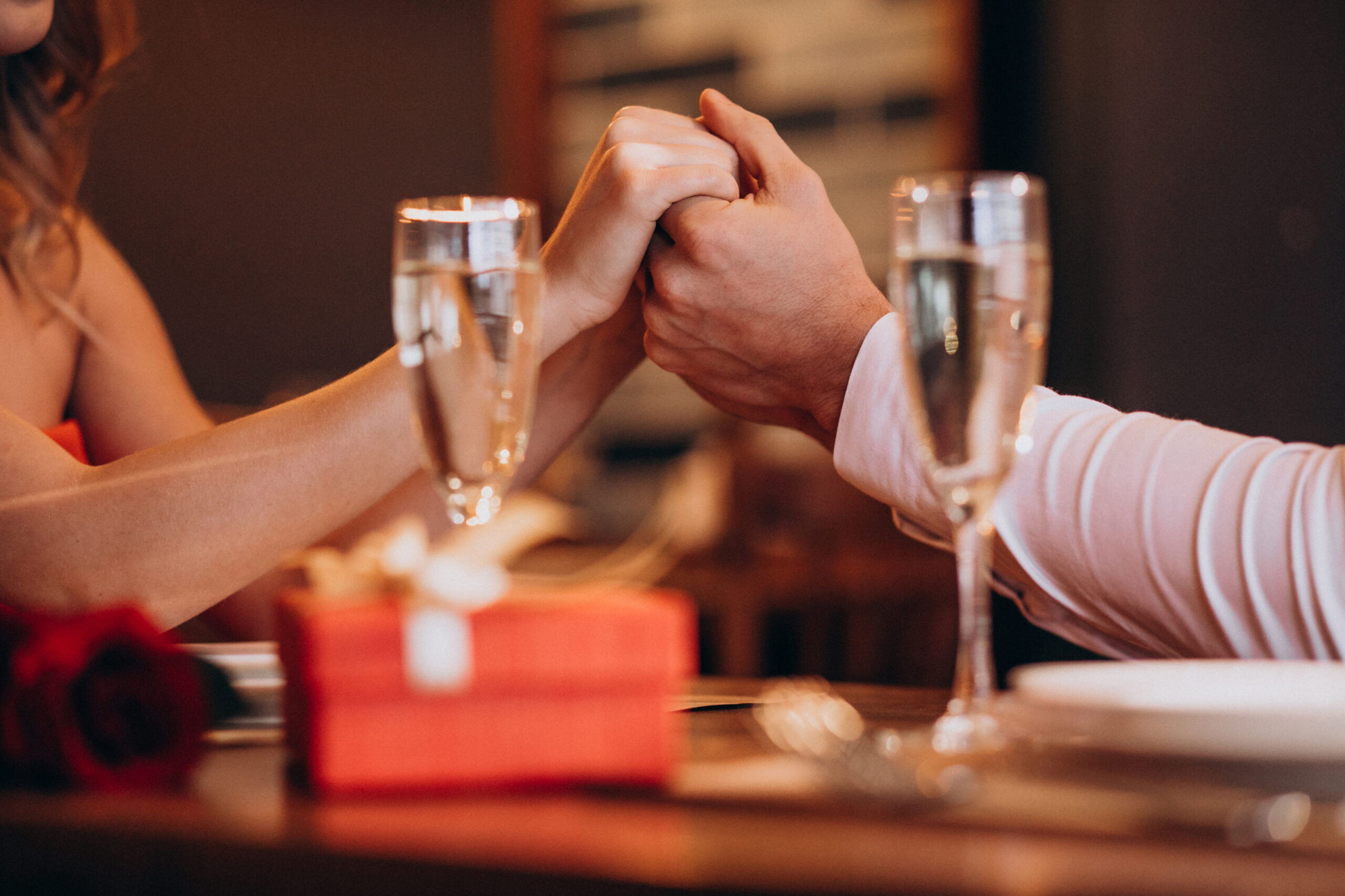 Couple Holding Hands On Valentines Evening In A Restaurant